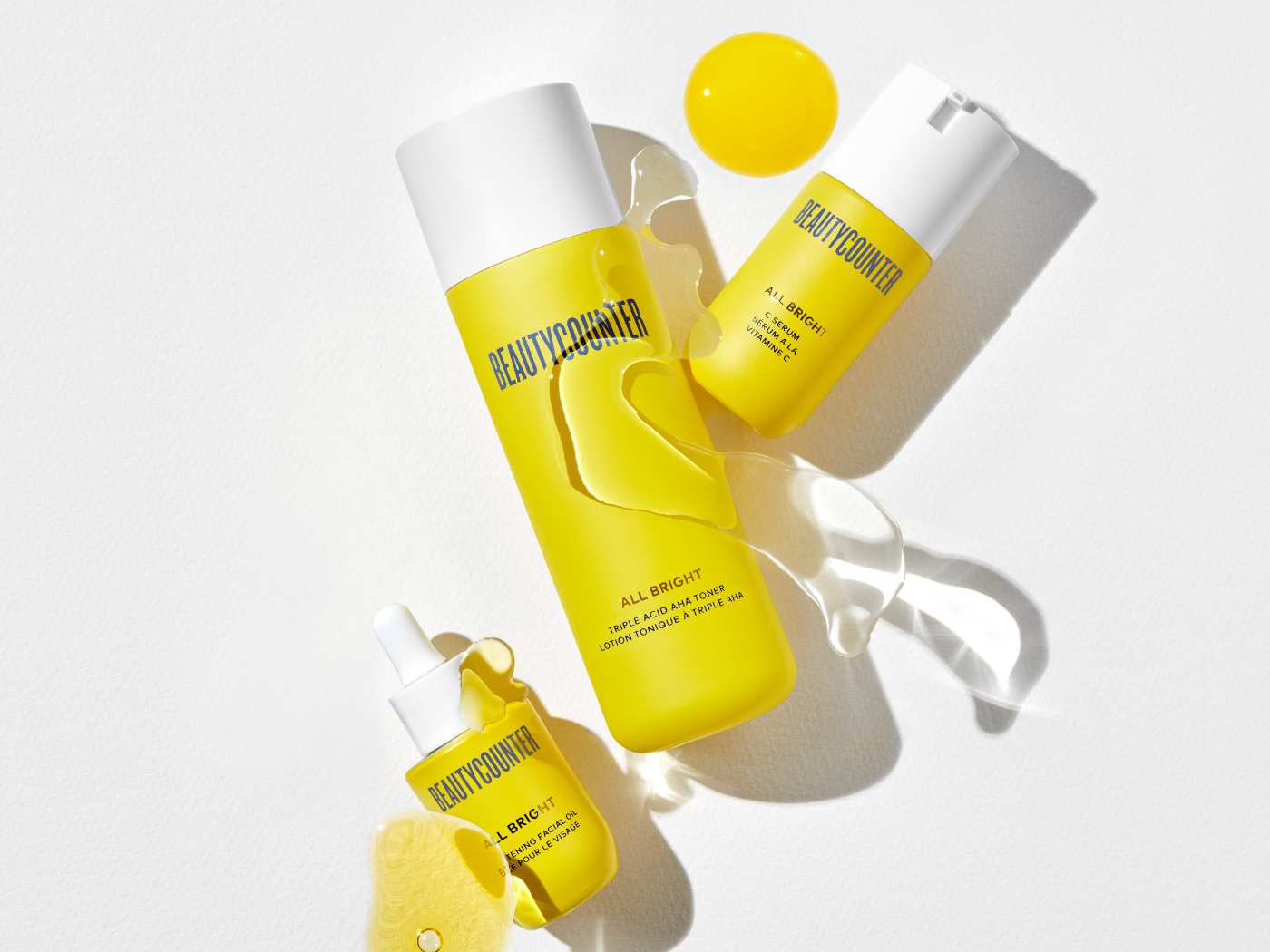 Yellow bottles with white tops for face care products and serums