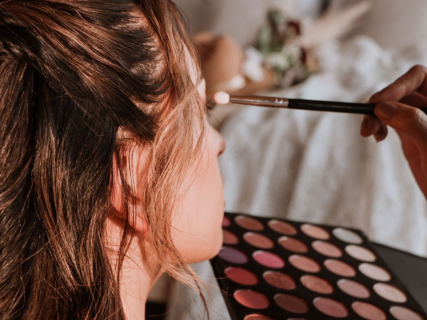 Make up artist applying eyeshadow to a woman's eyes using a brush