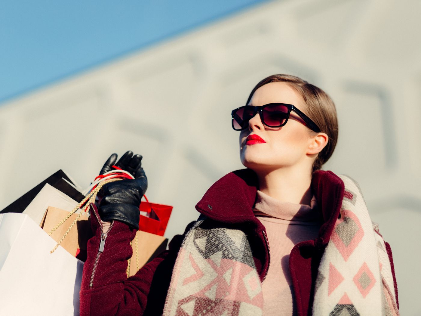 Woman wearing sunglasses and carrying shopping bags