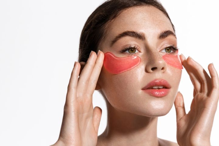 Woman wearing orange face mask patches under each eye