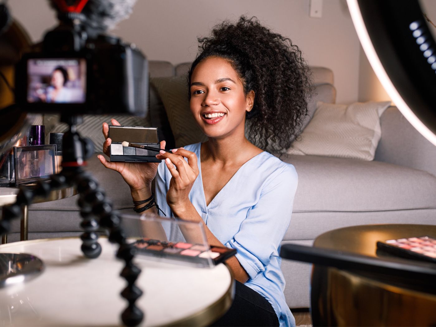 Female beauty influencer in front of cameras with a makeup palette