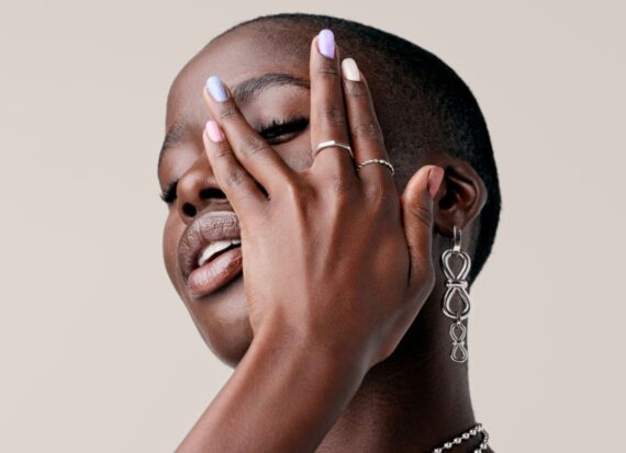 Model poses with different coloured nail polishes on each nail.