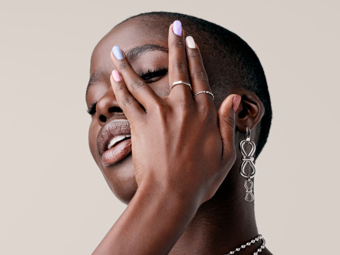 Model poses with different coloured nail polishes on each nail.